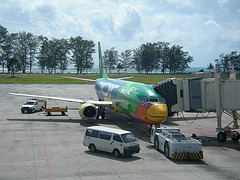 Phuket travel guide with nok air air craft parks on the run way.