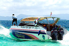Phi Phi Island private speedboat rent with man standing on the boat.